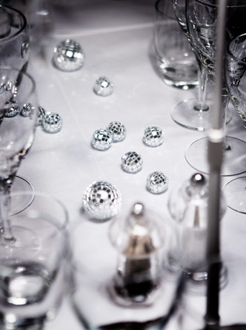 Bitte små disco balls pynter bordet i stedet for blomster i Copenhagen Island Hotels “Hvid Jul 2 tema/ event fest. Hvid porcelæn og klare crystal glas giver associationer til sne og is.